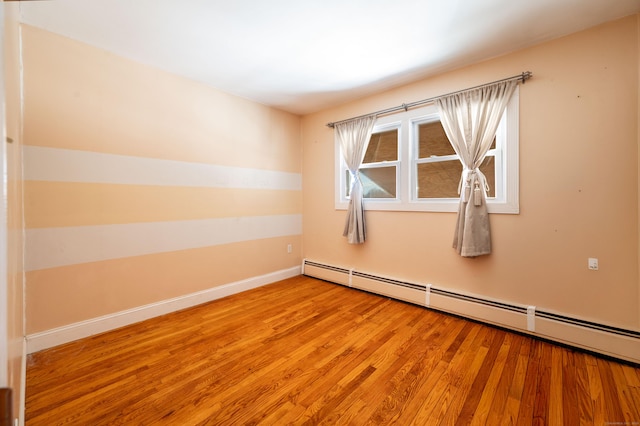 empty room featuring light hardwood / wood-style floors and baseboard heating