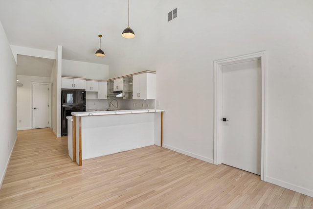 kitchen with visible vents, a peninsula, open shelves, white cabinets, and light wood-type flooring