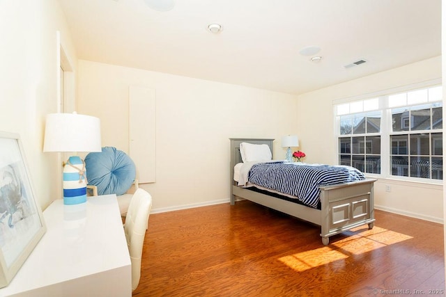 bedroom with dark hardwood / wood-style flooring