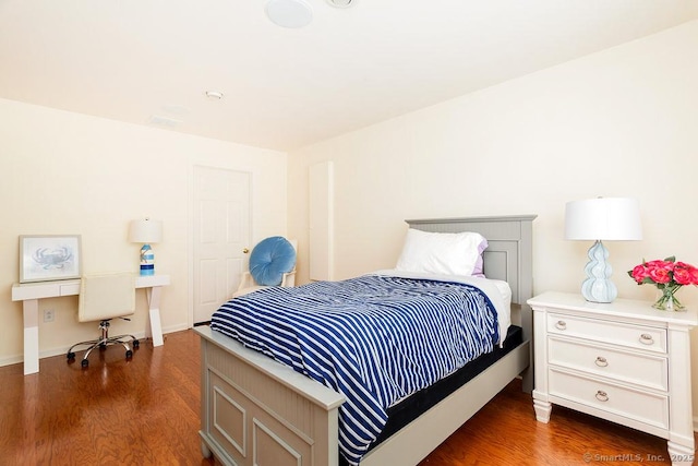 bedroom with dark hardwood / wood-style flooring