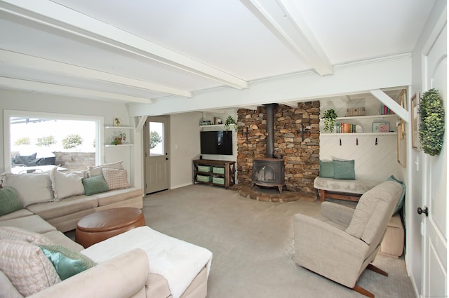 carpeted living room with beamed ceiling and a wood stove