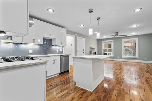 kitchen featuring hanging light fixtures, sink, white cabinets, and stainless steel appliances