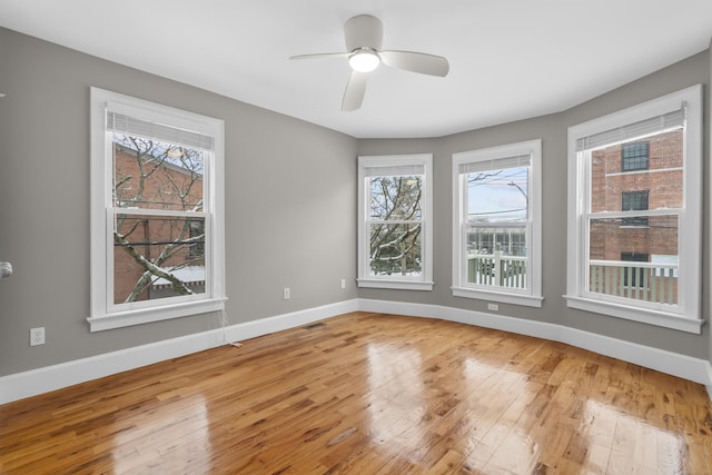 empty room with ceiling fan and hardwood / wood-style floors