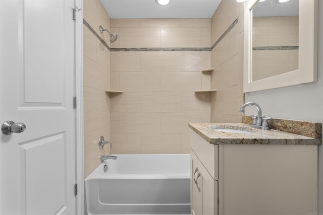 bathroom with tiled shower / bath and vanity