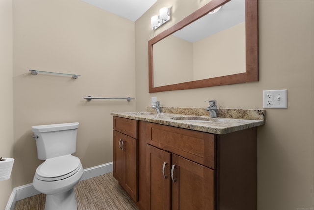 bathroom featuring hardwood / wood-style flooring, vanity, and toilet