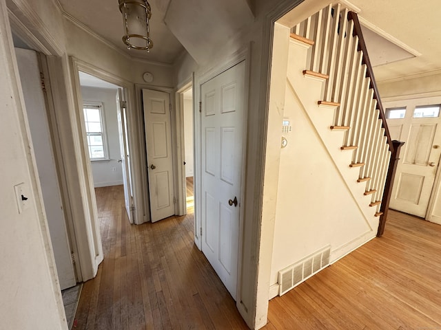 corridor featuring wood-type flooring and ornamental molding