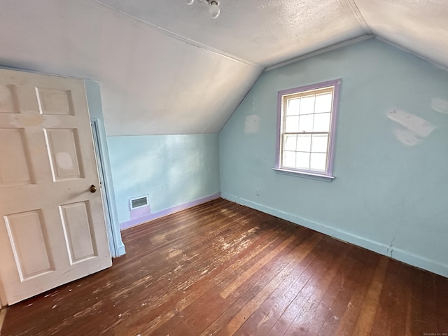 additional living space featuring lofted ceiling and dark hardwood / wood-style flooring