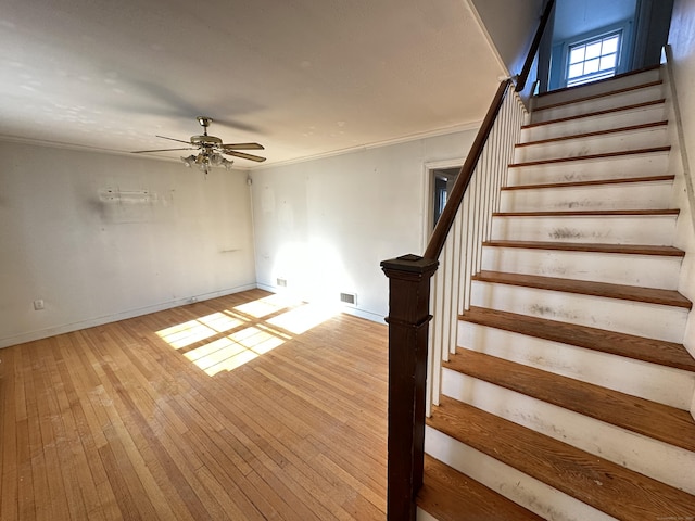 stairway featuring hardwood / wood-style floors and ceiling fan