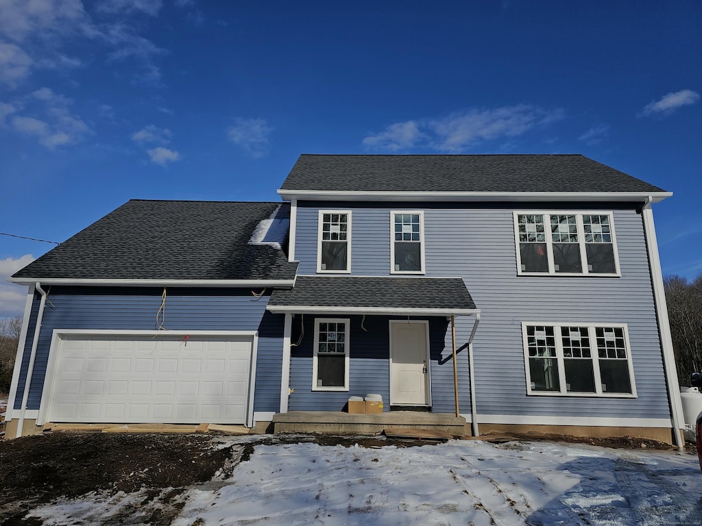 view of property with a garage and covered porch