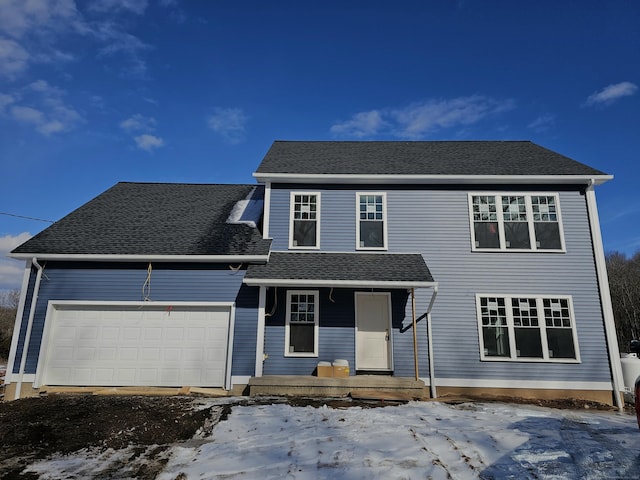 view of property with a garage and covered porch