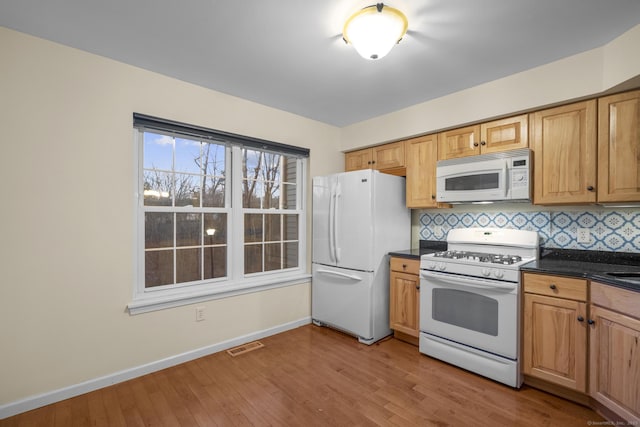 kitchen featuring tasteful backsplash, white appliances, and light hardwood / wood-style floors