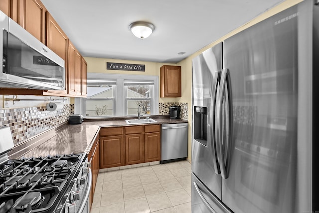 kitchen with light tile patterned flooring, appliances with stainless steel finishes, sink, and decorative backsplash