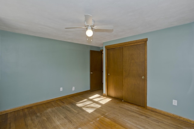 unfurnished bedroom featuring ceiling fan, a closet, and light hardwood / wood-style flooring