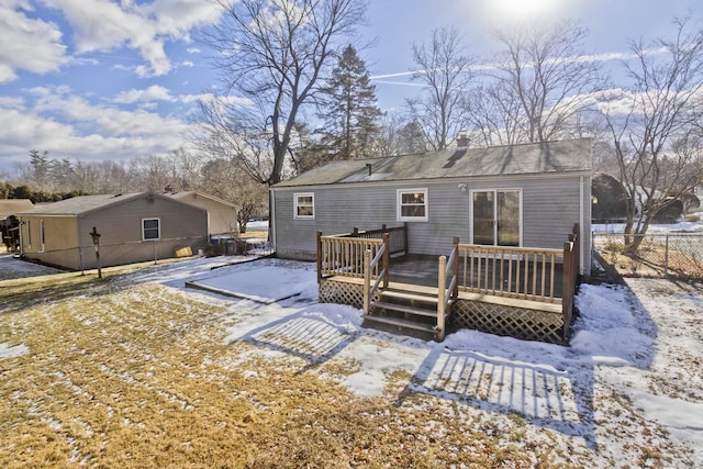 snow covered back of property with a deck