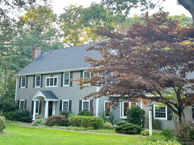 colonial house featuring a front lawn