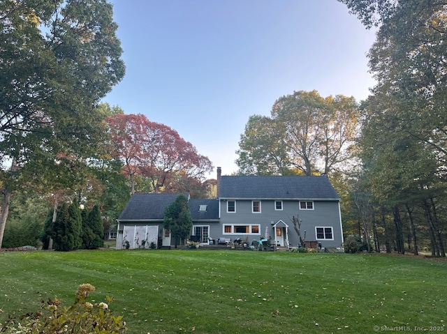 rear view of property featuring a yard