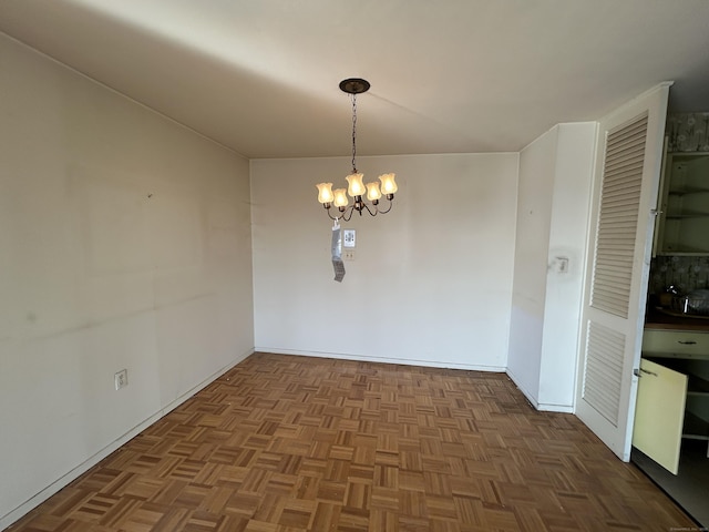 unfurnished dining area with parquet flooring and a chandelier