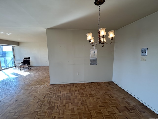 unfurnished dining area featuring dark parquet floors and a chandelier