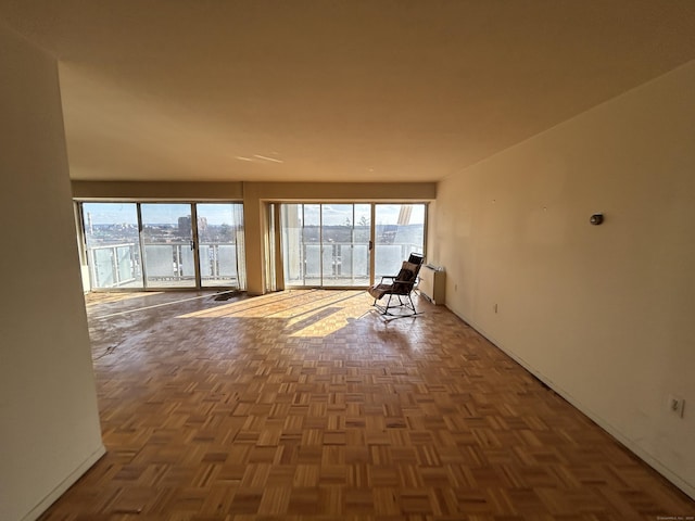 empty room with a water view and dark parquet flooring