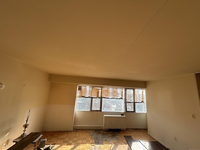 empty room with radiator heating unit and light parquet floors