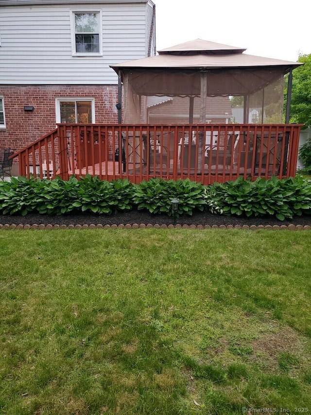 back of property with a gazebo, a yard, and a deck