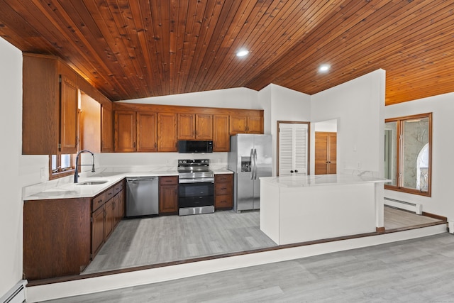 kitchen with a baseboard heating unit, vaulted ceiling, stainless steel appliances, and sink