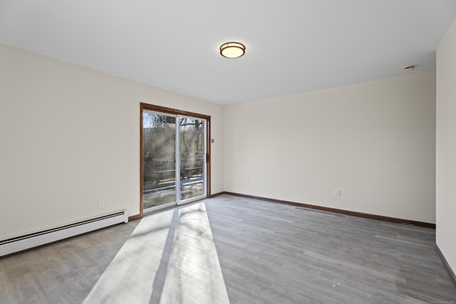 empty room with hardwood / wood-style flooring and a baseboard radiator