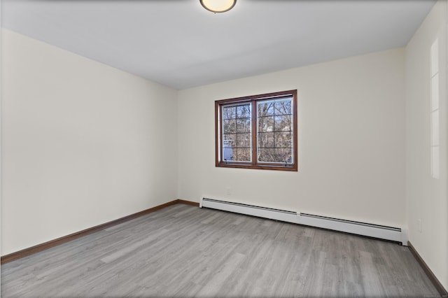 spare room with light hardwood / wood-style floors and a baseboard heating unit