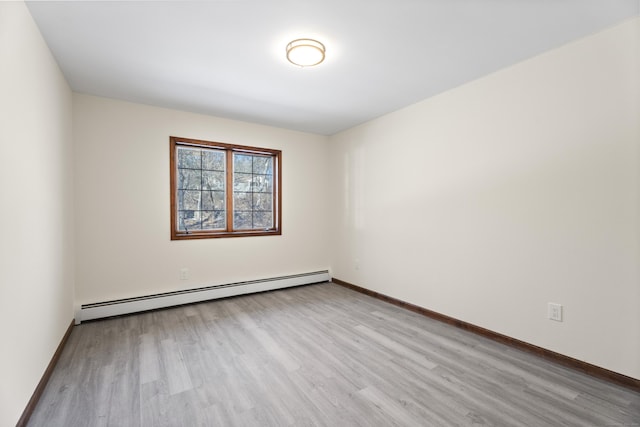 empty room featuring baseboard heating and light hardwood / wood-style flooring