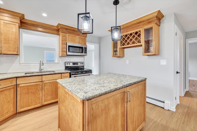 kitchen with a kitchen island, appliances with stainless steel finishes, sink, baseboard heating, and light stone countertops