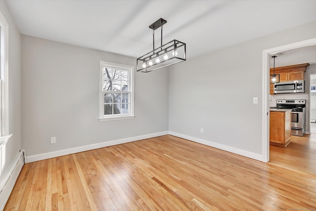 unfurnished dining area with a baseboard radiator and light wood-type flooring