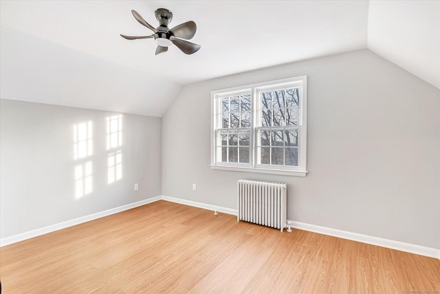 bonus room with lofted ceiling, radiator, light hardwood / wood-style floors, and ceiling fan