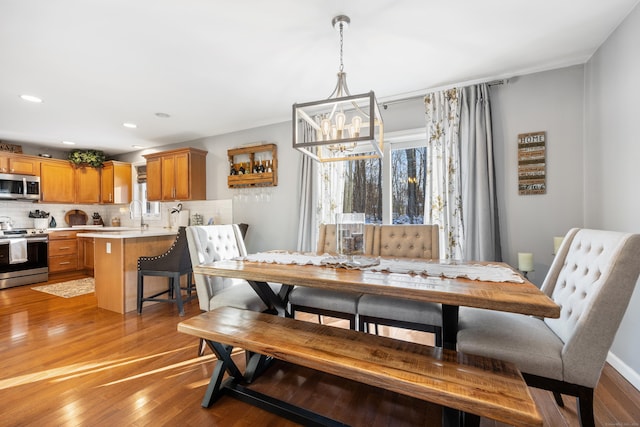 dining area with wood-type flooring and a chandelier