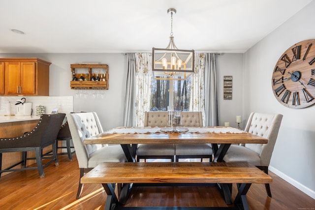 dining area with hardwood / wood-style floors and a chandelier