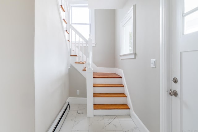 staircase featuring plenty of natural light and a baseboard heating unit