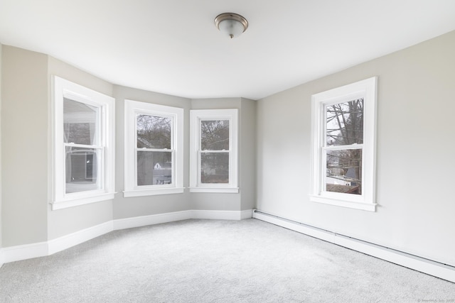 carpeted spare room with a baseboard heating unit