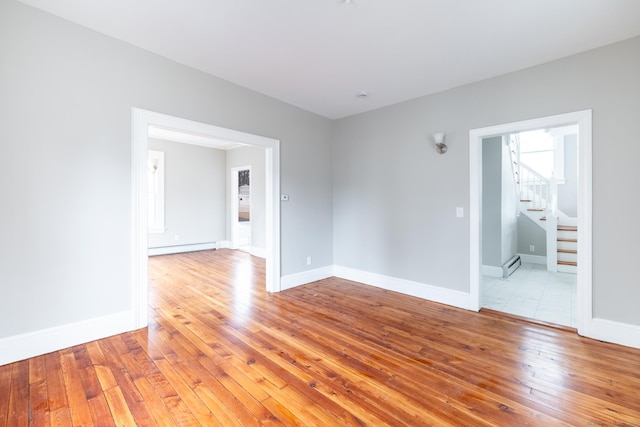 spare room featuring light wood-type flooring and a baseboard heating unit