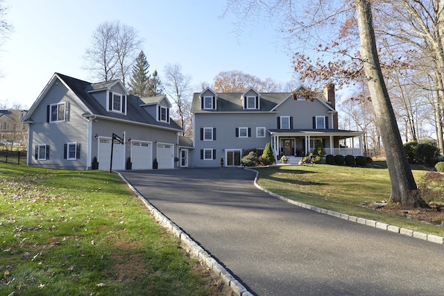 view of front of property featuring a garage, a front lawn, and covered porch