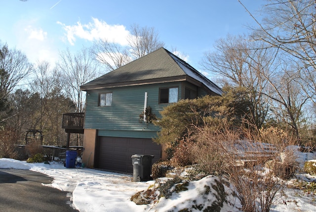 view of snowy exterior with a garage