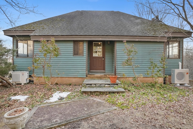 view of front of house with a shingled roof and ac unit