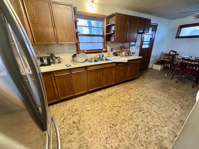 kitchen with stainless steel refrigerator, sink, and decorative backsplash