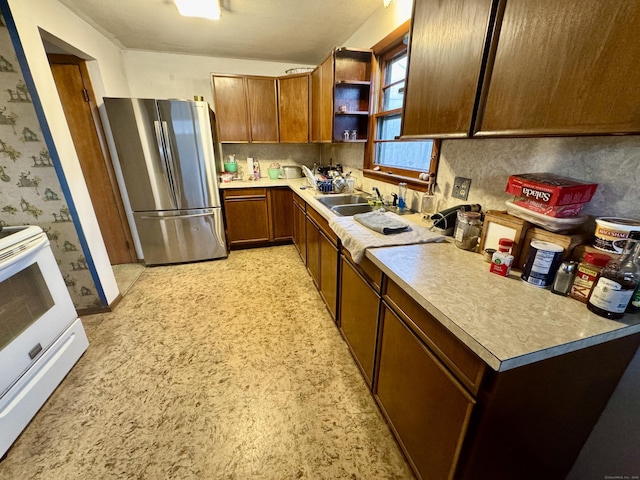 kitchen featuring white range with electric stovetop, sink, and stainless steel refrigerator