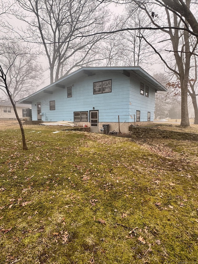 back of property featuring a lawn