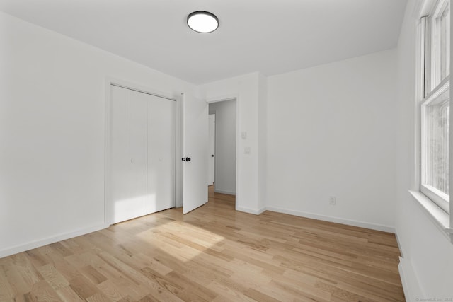 unfurnished bedroom featuring a closet and light hardwood / wood-style flooring