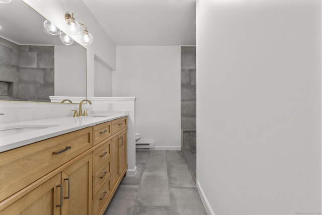 bathroom featuring vanity, a baseboard heating unit, and toilet