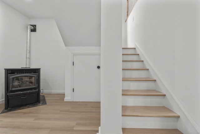 stairway with hardwood / wood-style flooring and a wood stove