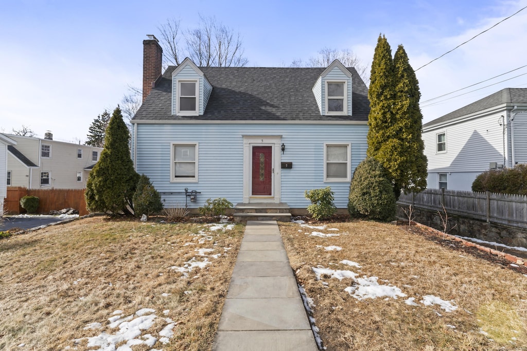 cape cod-style house with a front yard