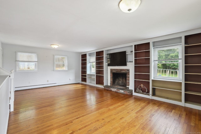 15 Seeley St, Danbury, CT 06810 - unfurnished living room featuring light wood-style floors, built in shelves, baseboard heating, a brick fireplace, and baseboards