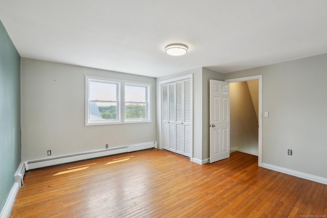 15 Seeley St, Danbury, CT 06810 - unfurnished bedroom featuring baseboard heating, light wood-type flooring, a closet, and baseboards