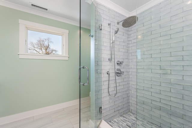 bathroom with ornamental molding and an enclosed shower